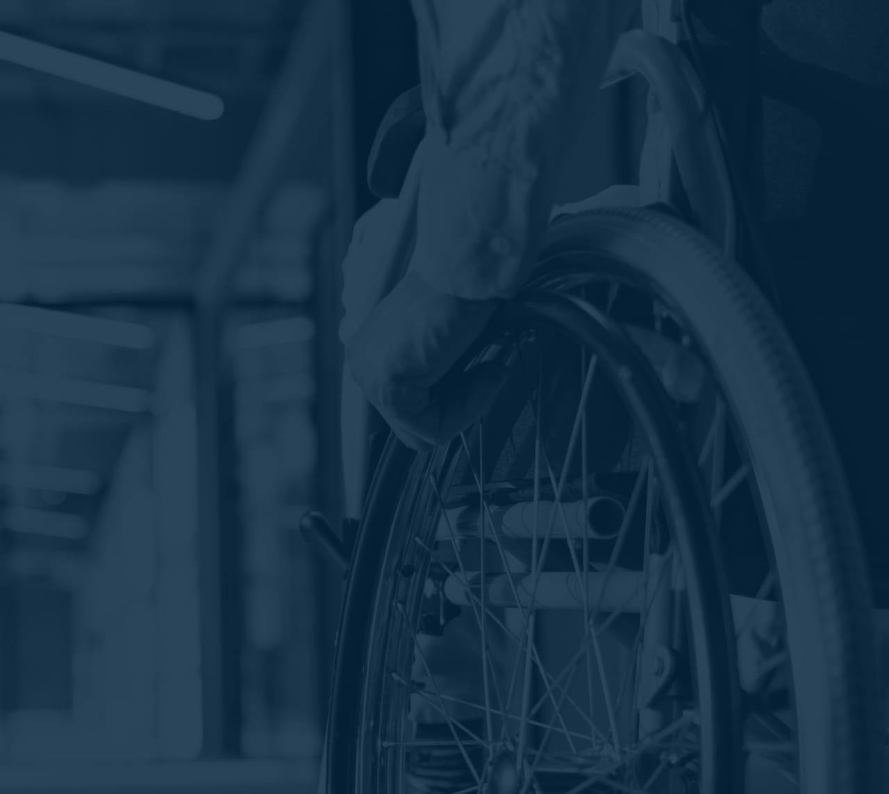 Person in a wheelchair, image has a blue filter over it