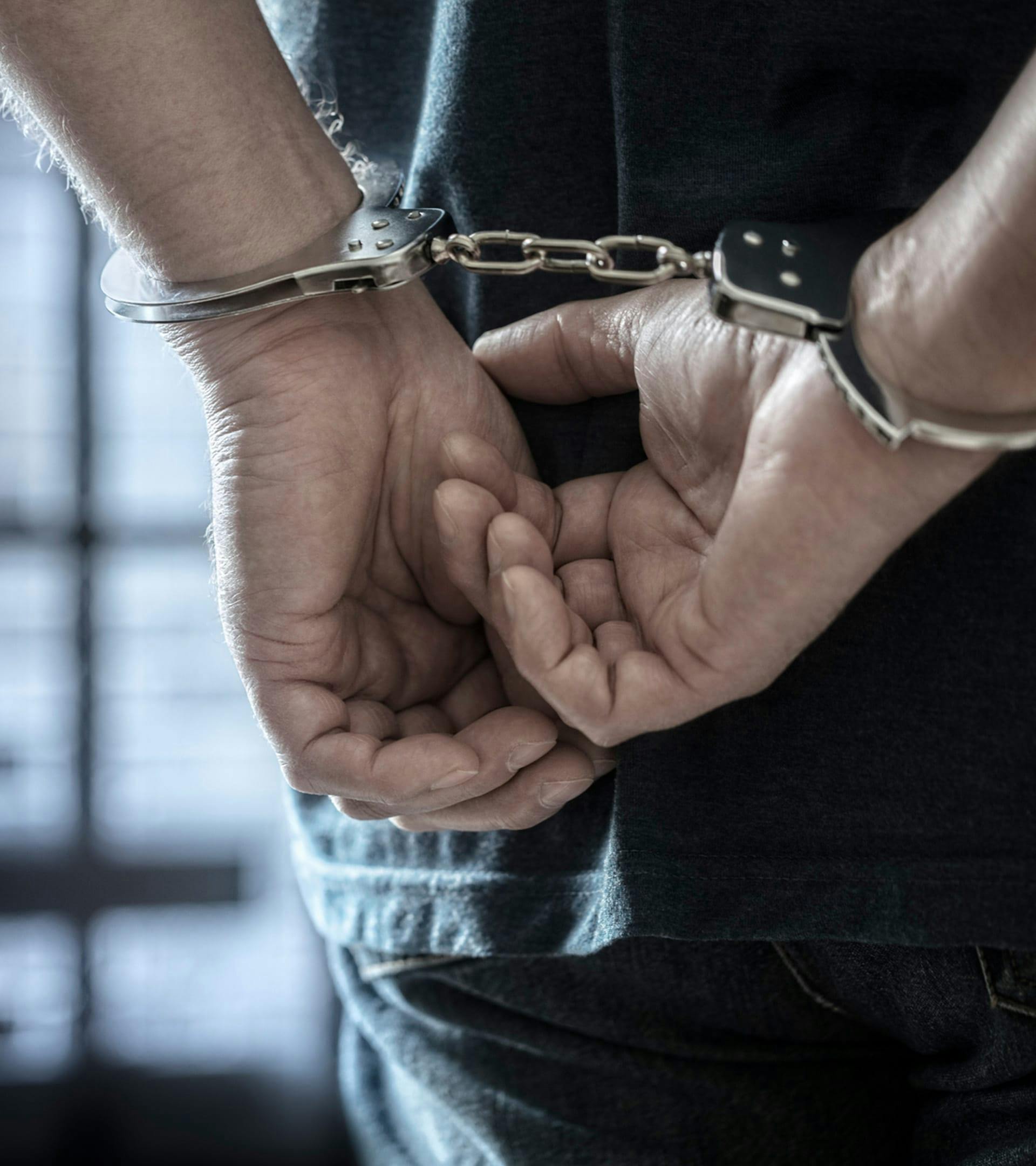 Man with hands handcuffed behind his back.