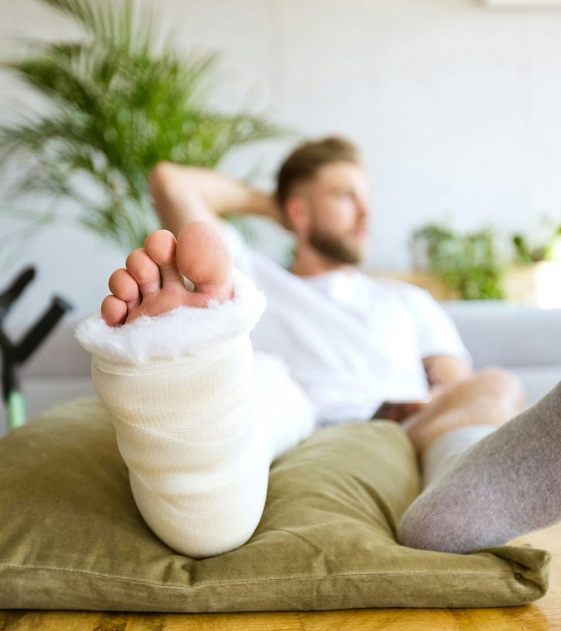 Man sitting with a cast on a leg.