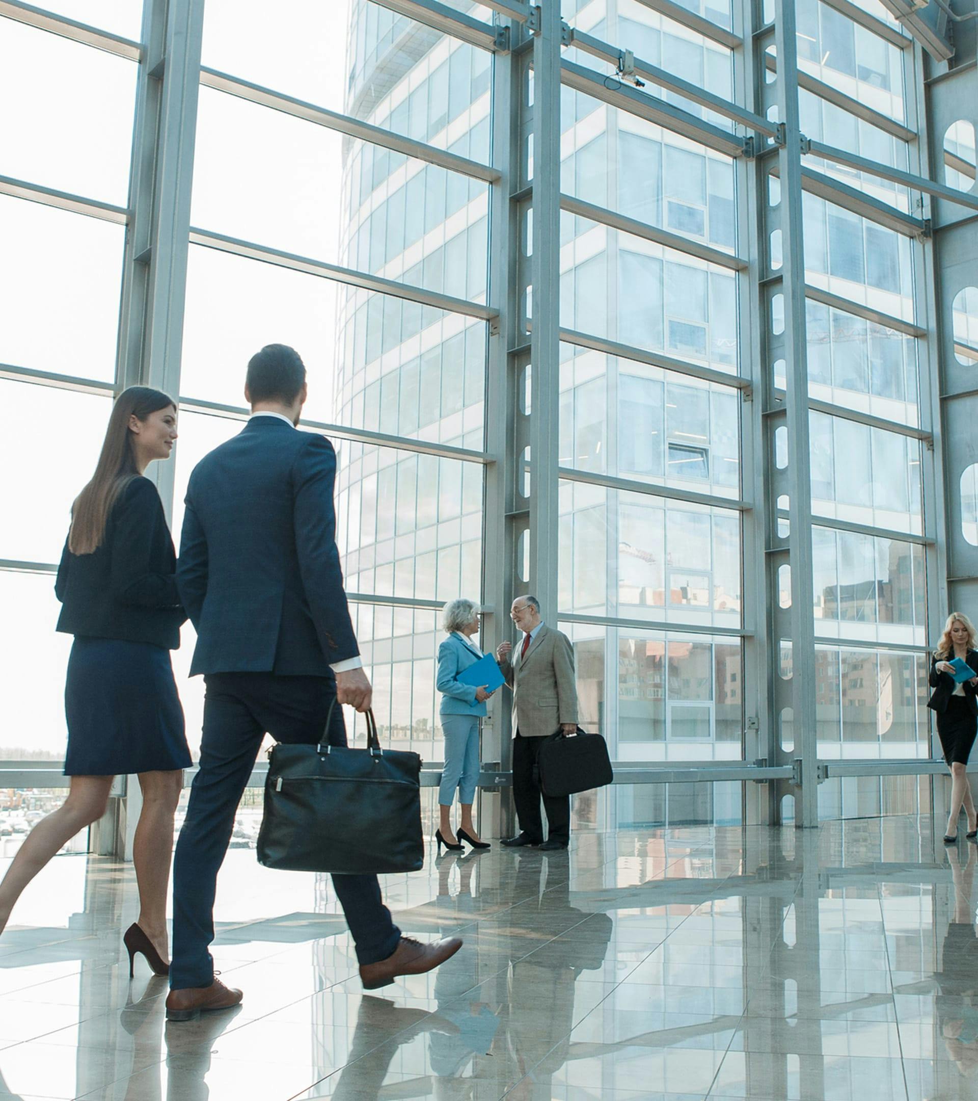 People walking in a building with big windows