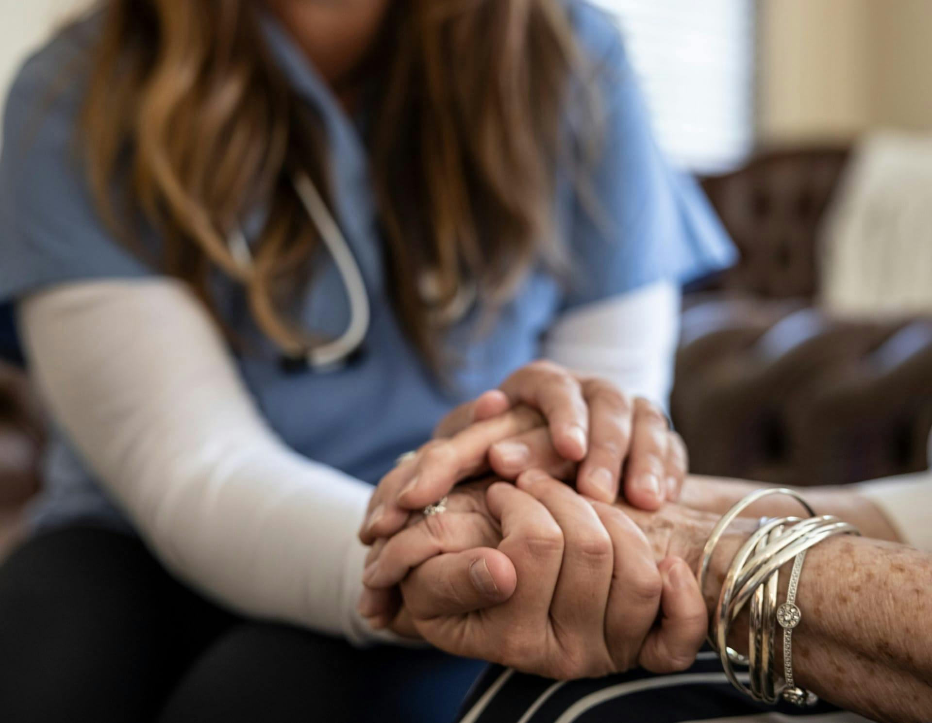 Nurse holding person's hand
