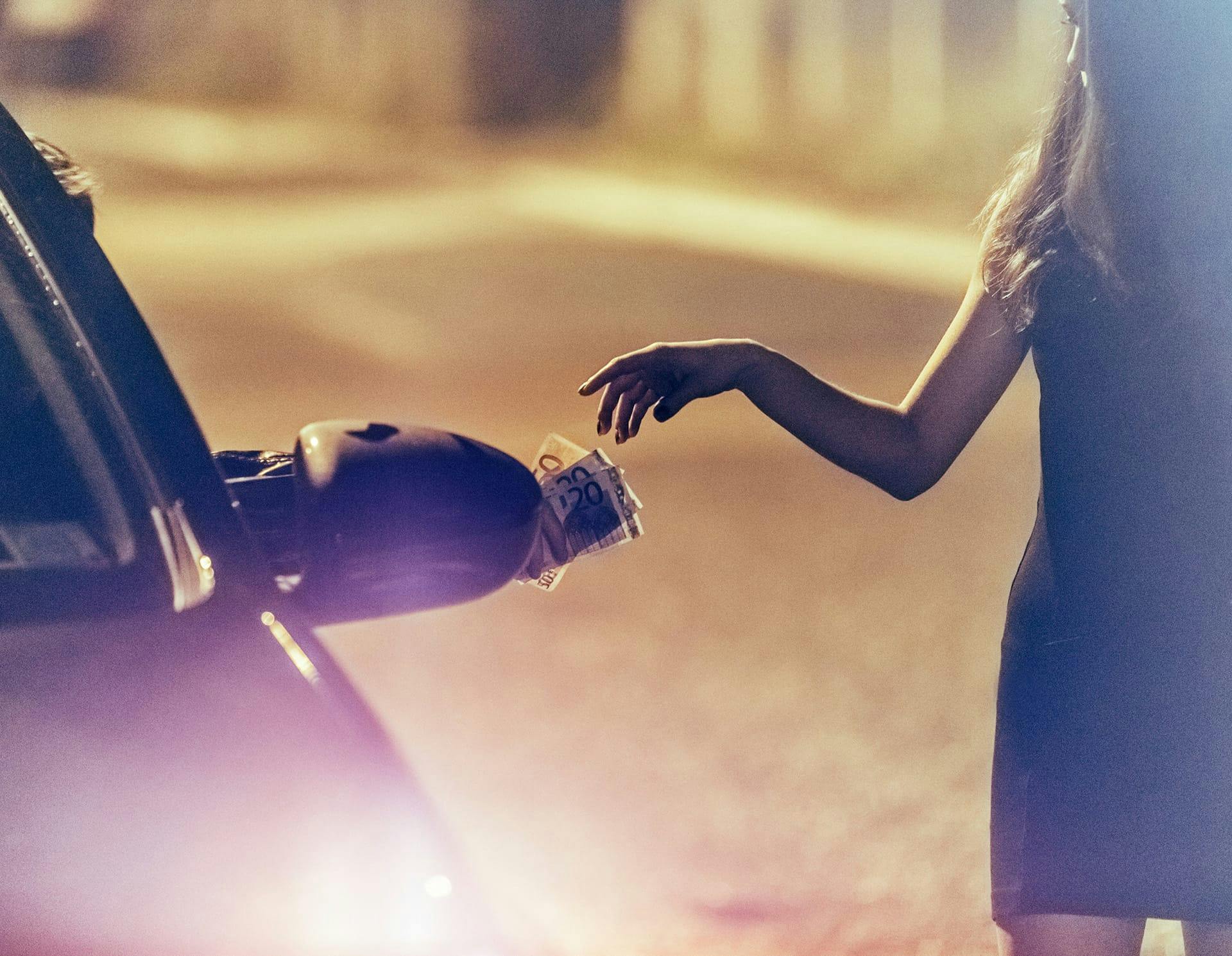 Woman receiving money from person in car