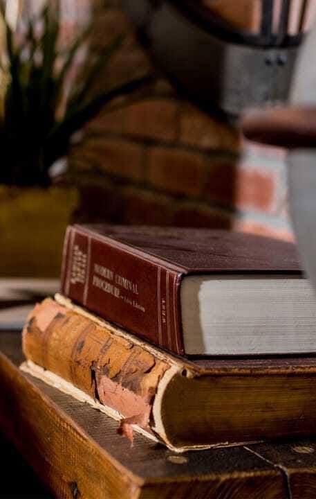 Stack of books in front of a brick wall background.