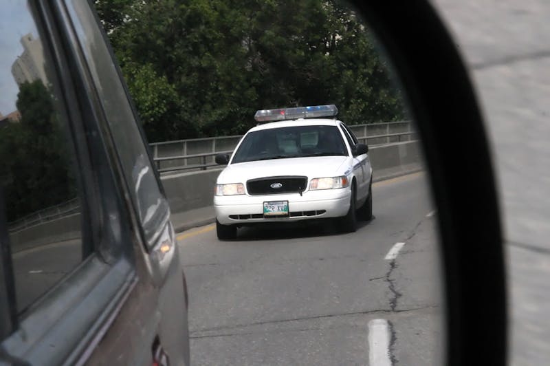 Police car in side view mirror.