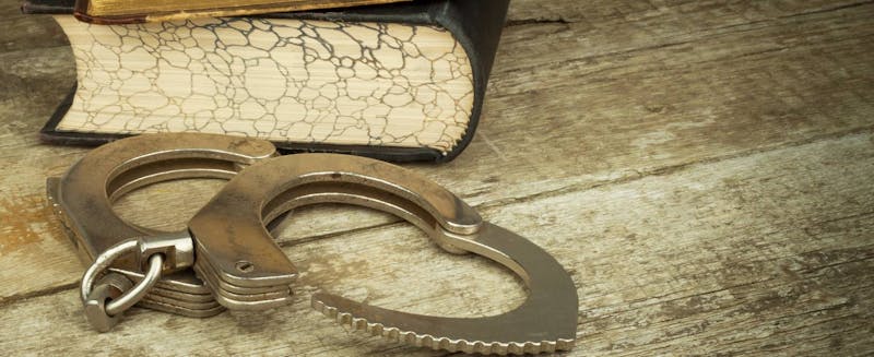 Handcuffs next to a book.