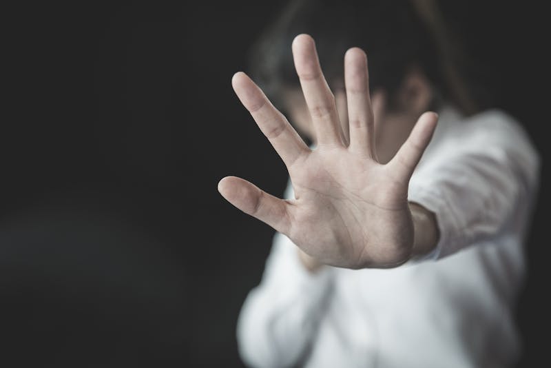 Woman with her hand held up.