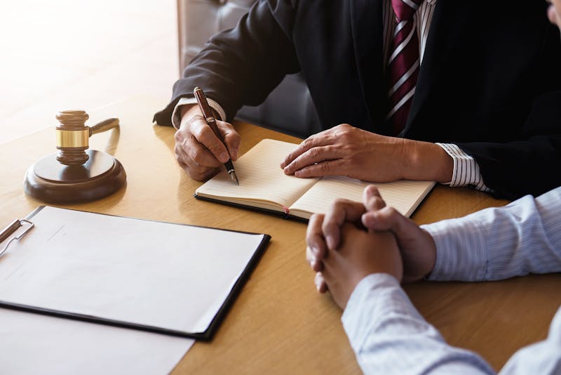 Two people sitting at a desk discussing something.