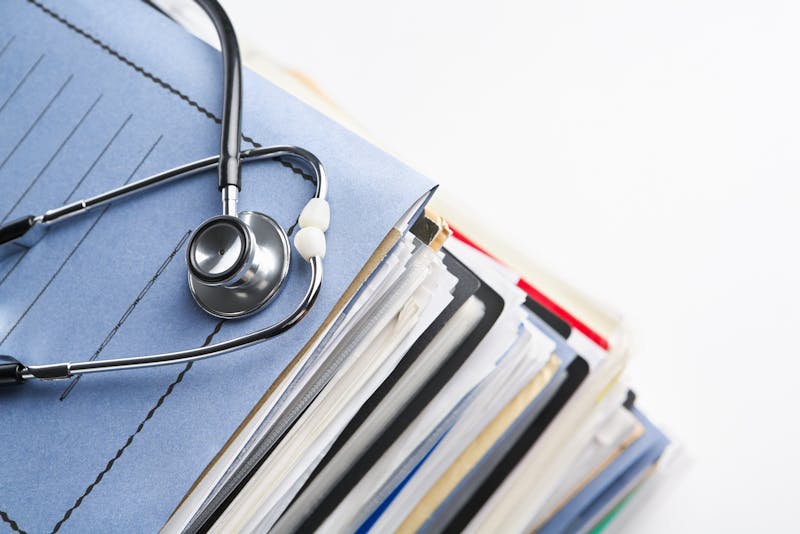 Doctor's medical files stacked up.
