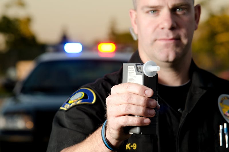 Police officer raising a breathalizer.