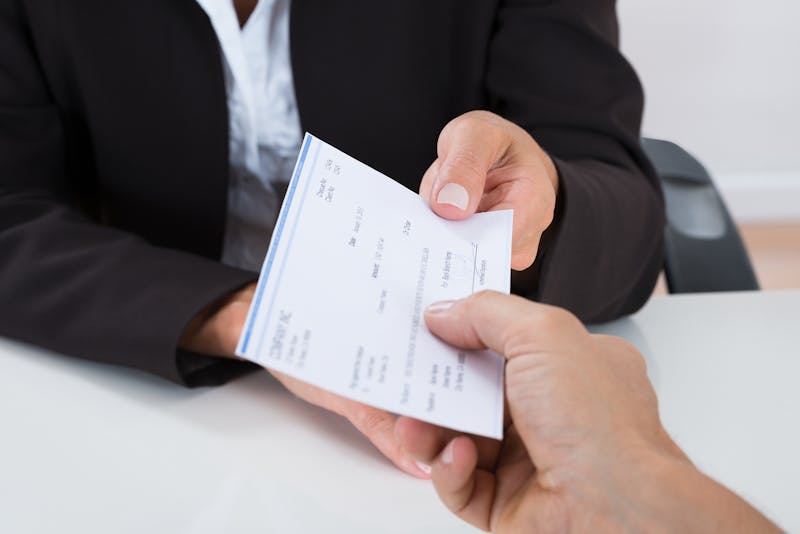 Person handing another person a check.