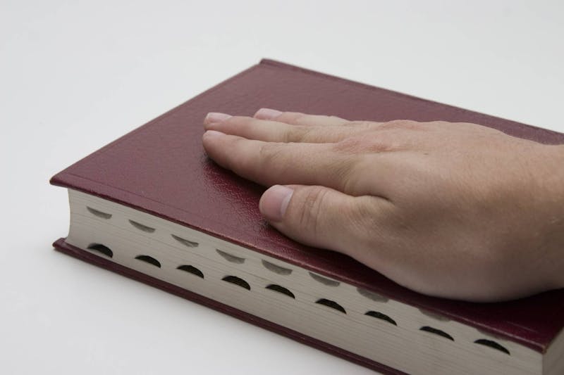 Hand on top of a book.