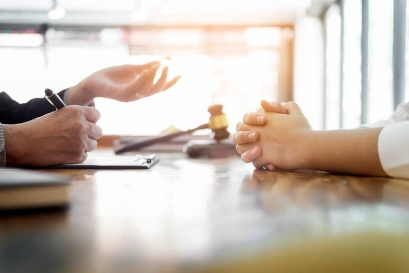 Two individuals talking in a legal office.