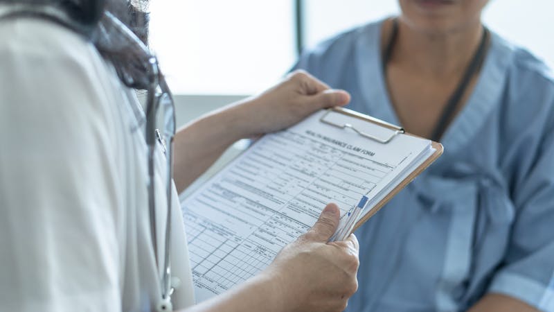 Doctor speaking with a patient and taking notes.