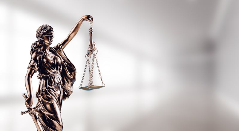 Scales of justice hanging from a figure.