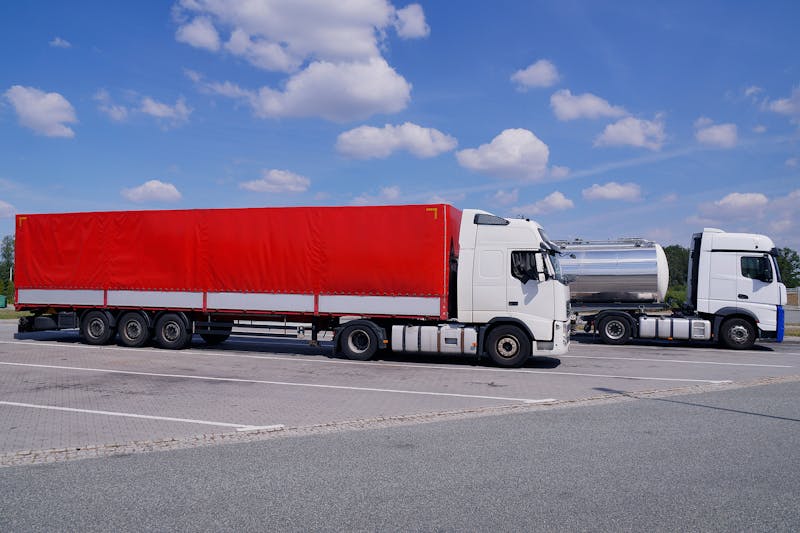 Two commercial trucks in a parking lot.