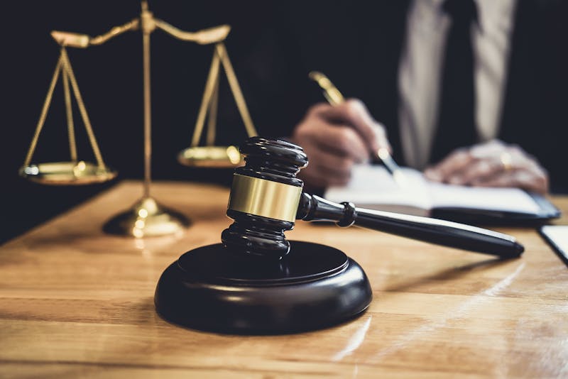 Gavel and block in front of the scales of justice.