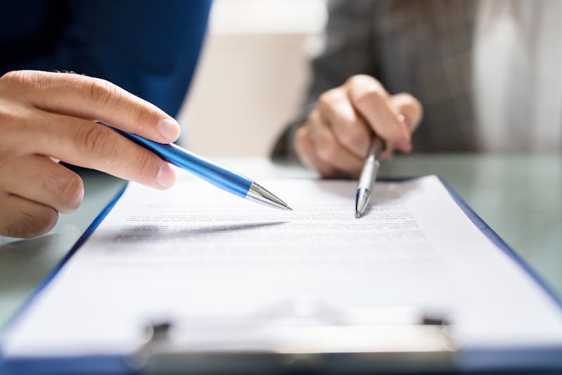 Two people reviewing a piece of paper.