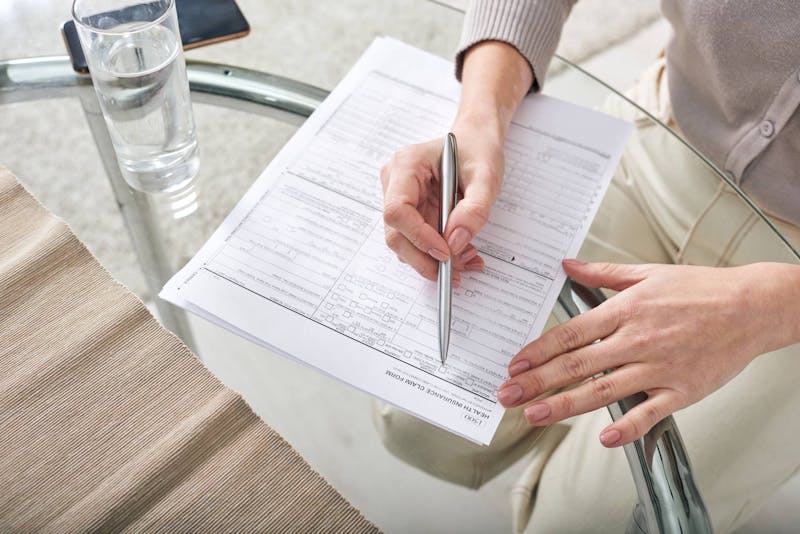 Woman filling out a legal form on a table.
