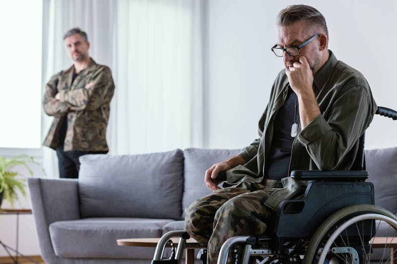 Man in a wheelchair wearing camo gear.
