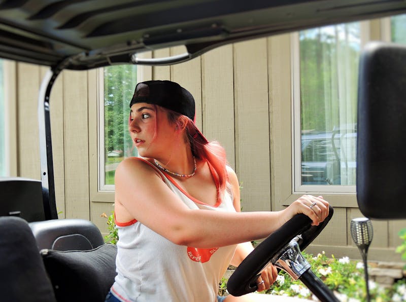 Teenage girl driving a golf cart