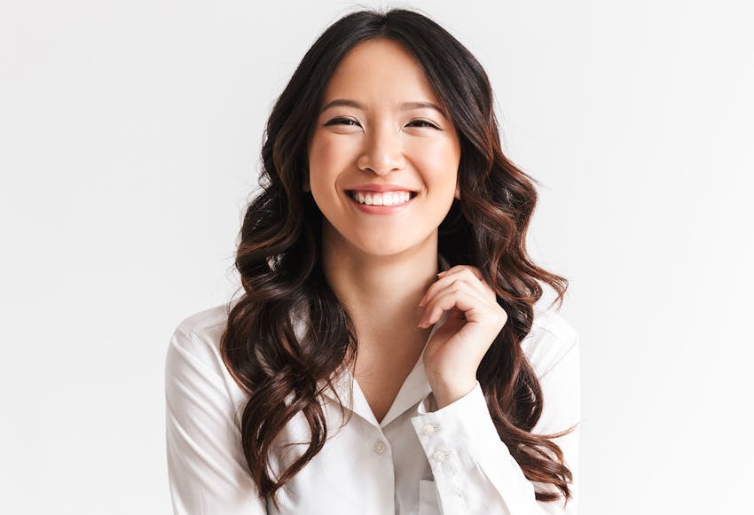Woman with long curly dark hair smiling