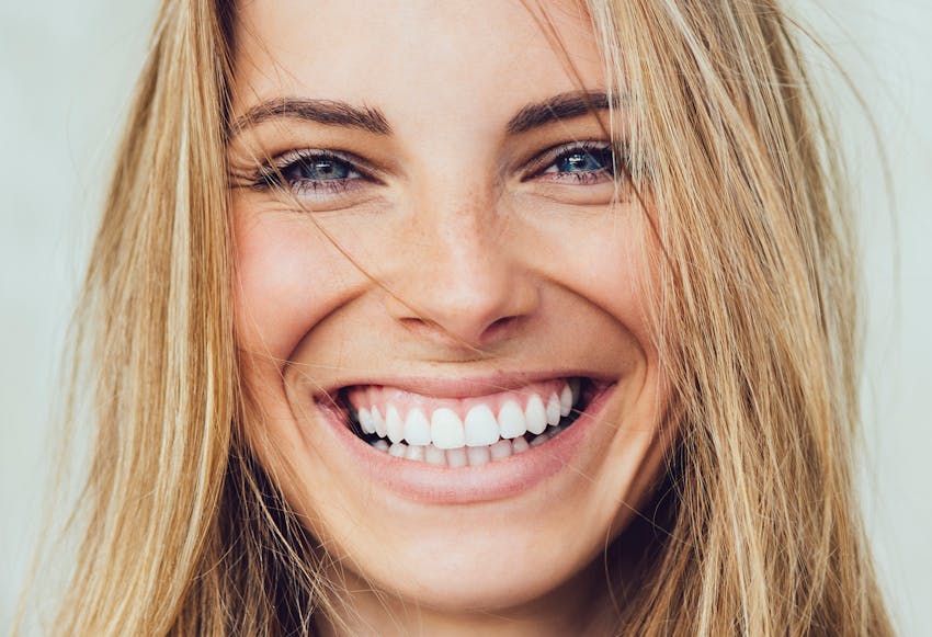Woman with blonde hair and blue eyes smiling