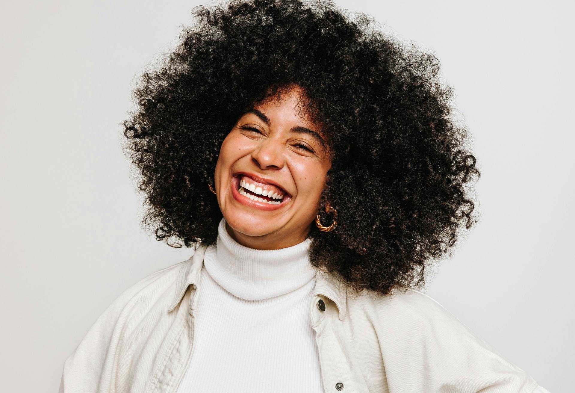 Woman with big curly black hair smiling