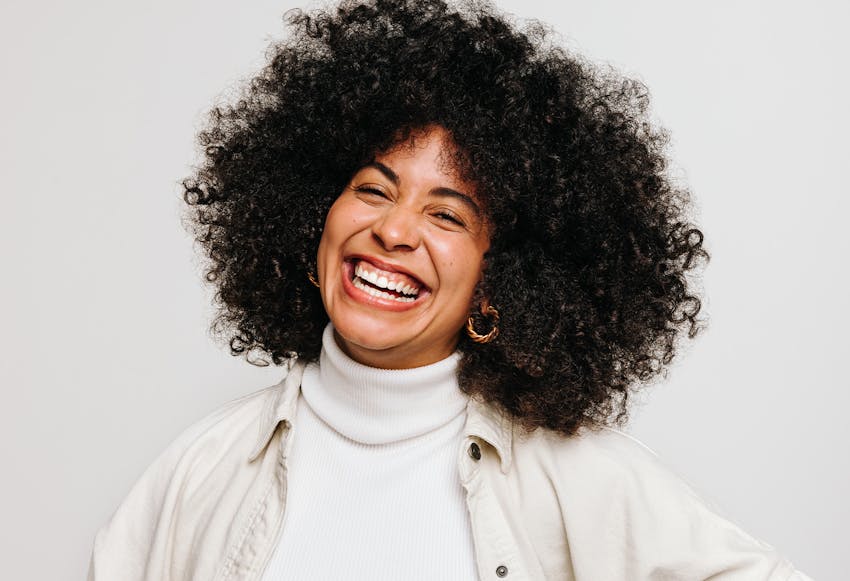 Woman with big curly black hair smiling