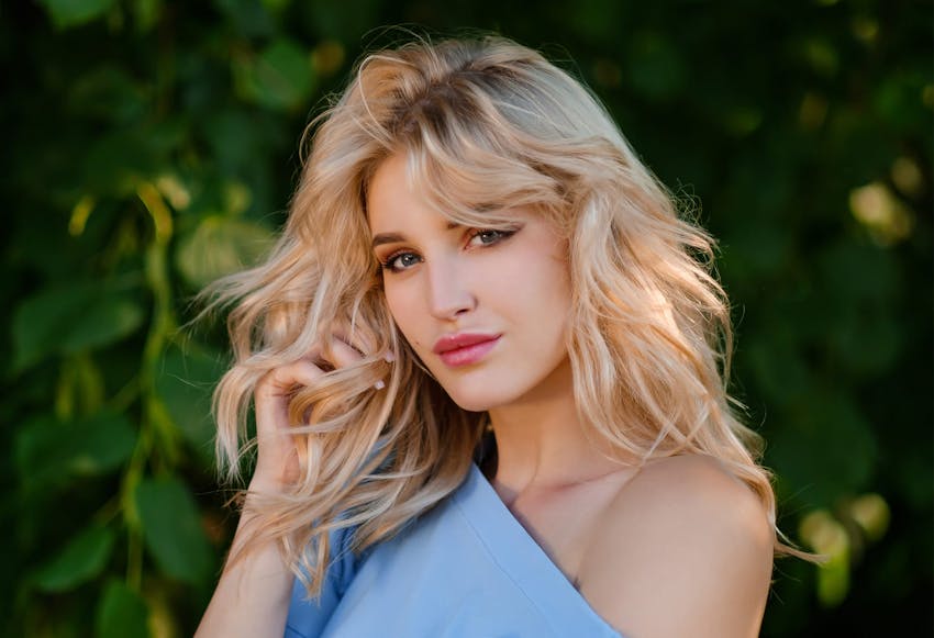 Woman with blonde hair wearing a blue top