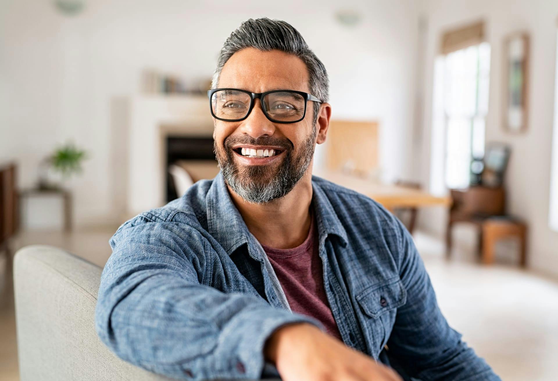 Man with salt and pepper hair wearing glasses and smiling