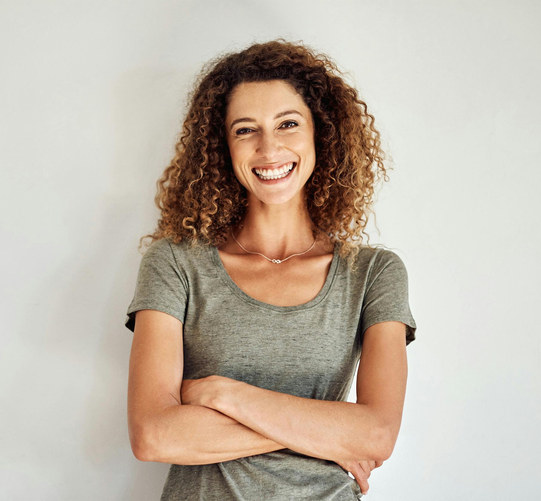 Woman with very curly hair, arms crossed