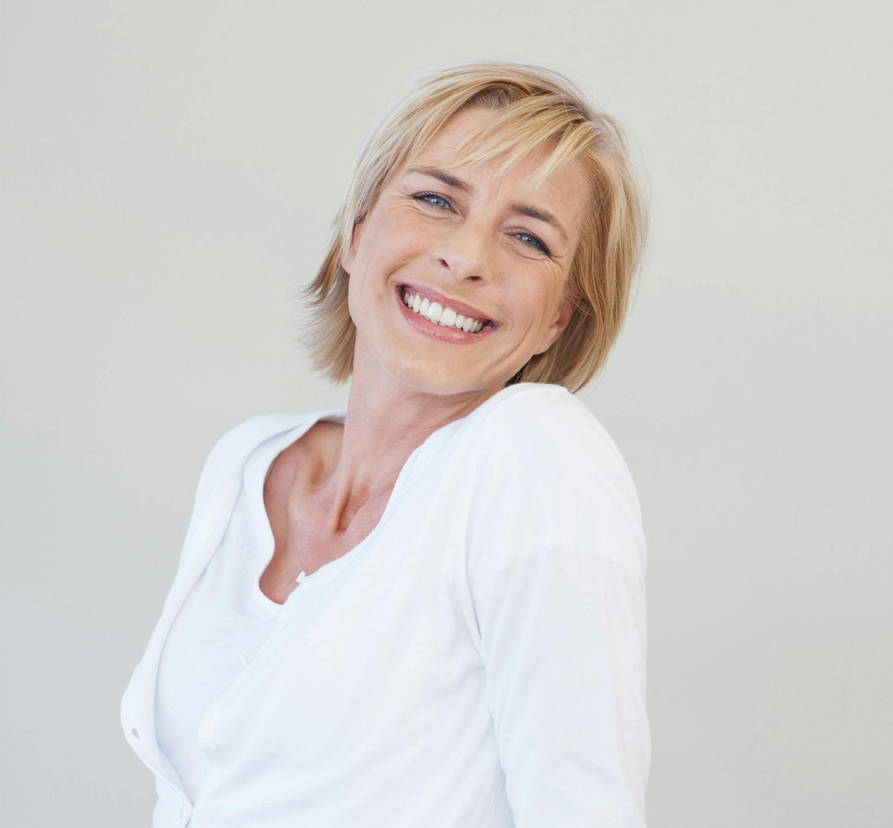 Blonde woman smiling over her shoulder