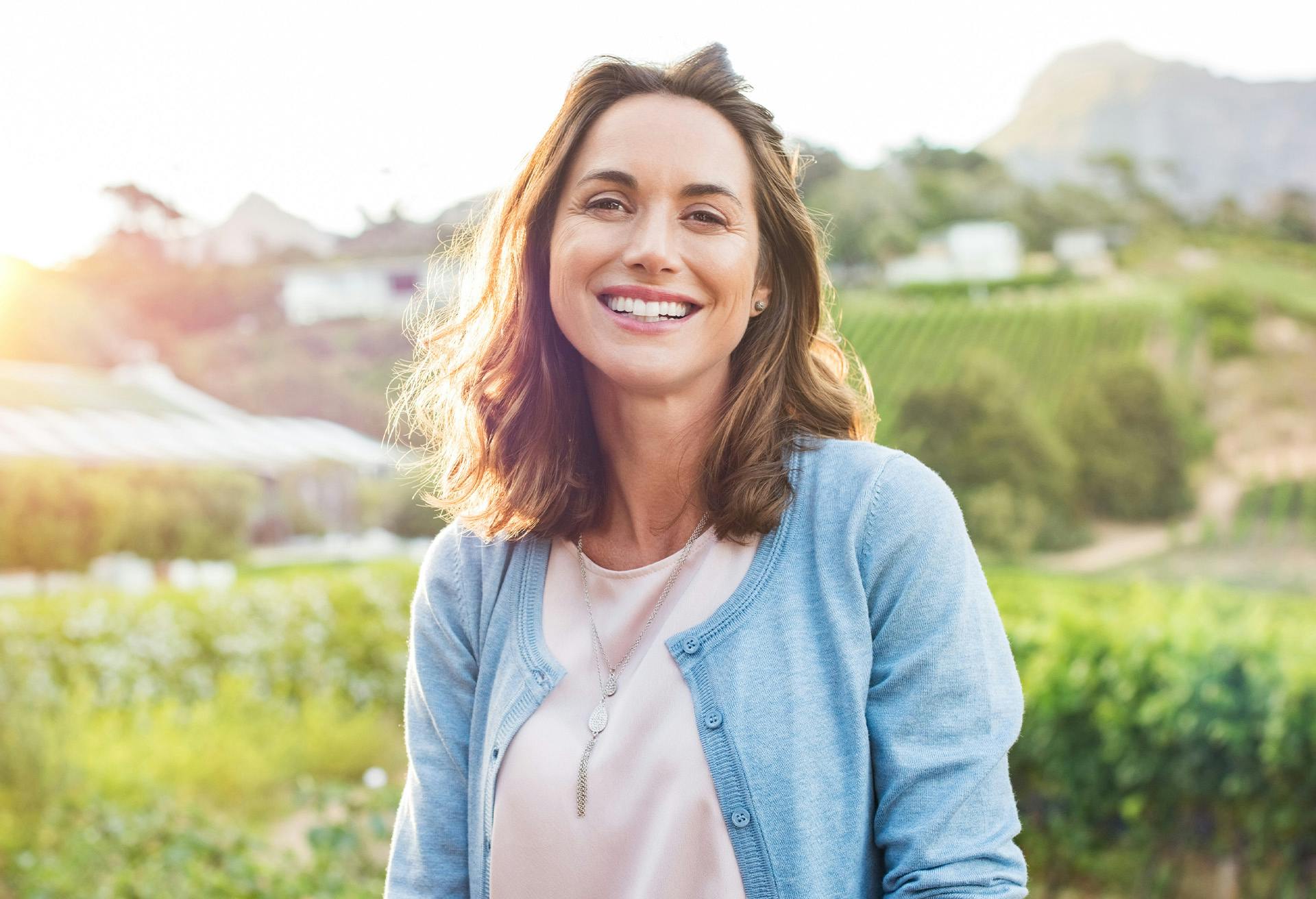 Woman in a sweater smiling outside