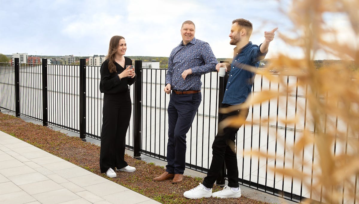 Tre kollegor står och pratar med varandra på takterrassen på Midagons Örebrokontor.